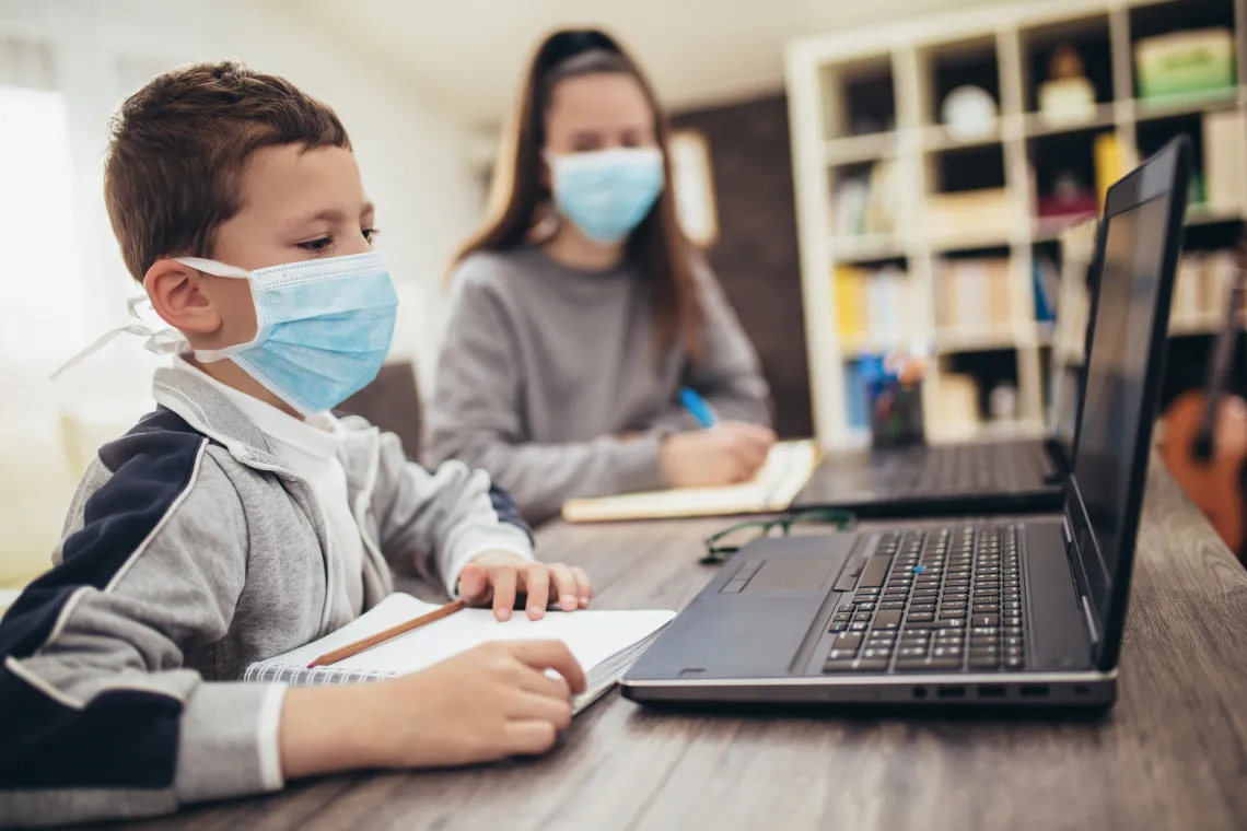 Kids on the computer wearing masks