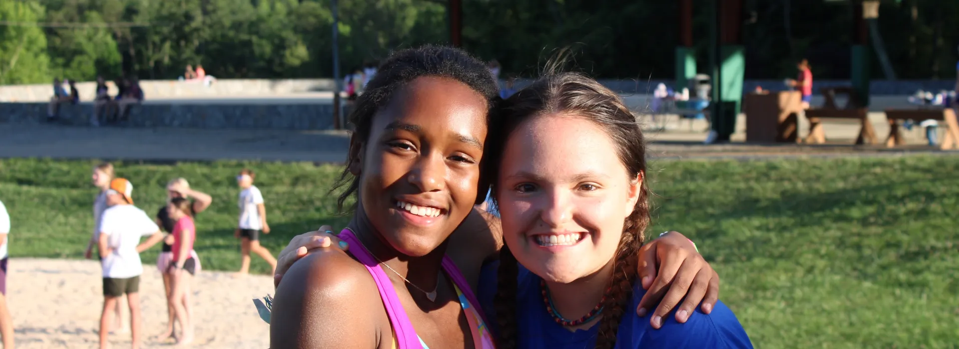 Two girls hugging in a field